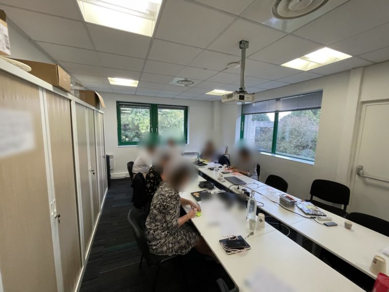 Manager débordé : des managers penchés sur leurs dossiers autour d'une longue table, chacun dans sa pile